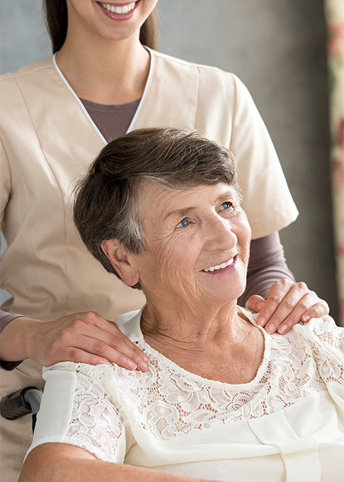 Elderly woman with caregiver smiling